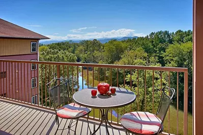 A table with two chairs overlooking the Pigeon River at Appleview River Resort in the Smoky Mountains.